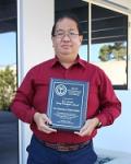 Dr. Kristianto Tjiptowidjojo, Research Assistant Professor, Department of  Chemical and Biological Engineering, University of New Mexico holding the awarded plaque