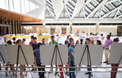 Students in EER building atrium, sharing research posters