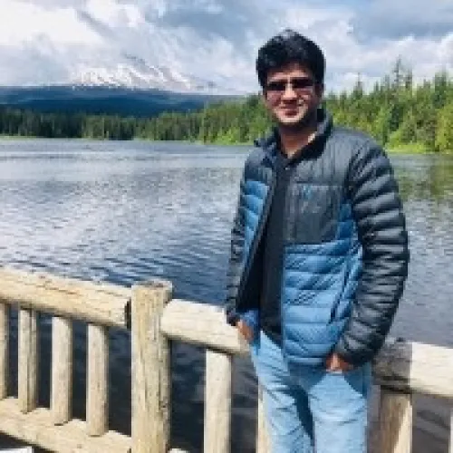 Aseem Sayal standing in front of a lake