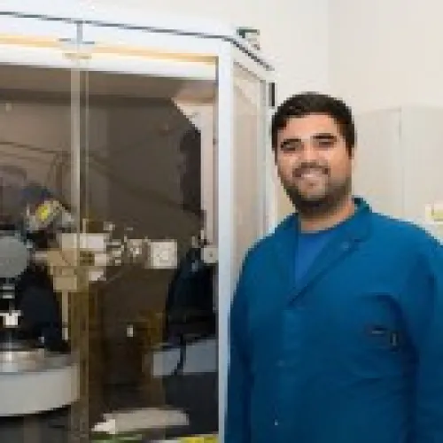 Photo of Carlos Favela next to machine tool