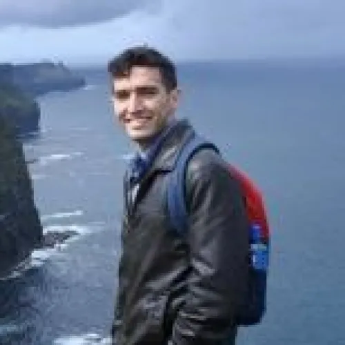David Cayll hiking with ocean in background